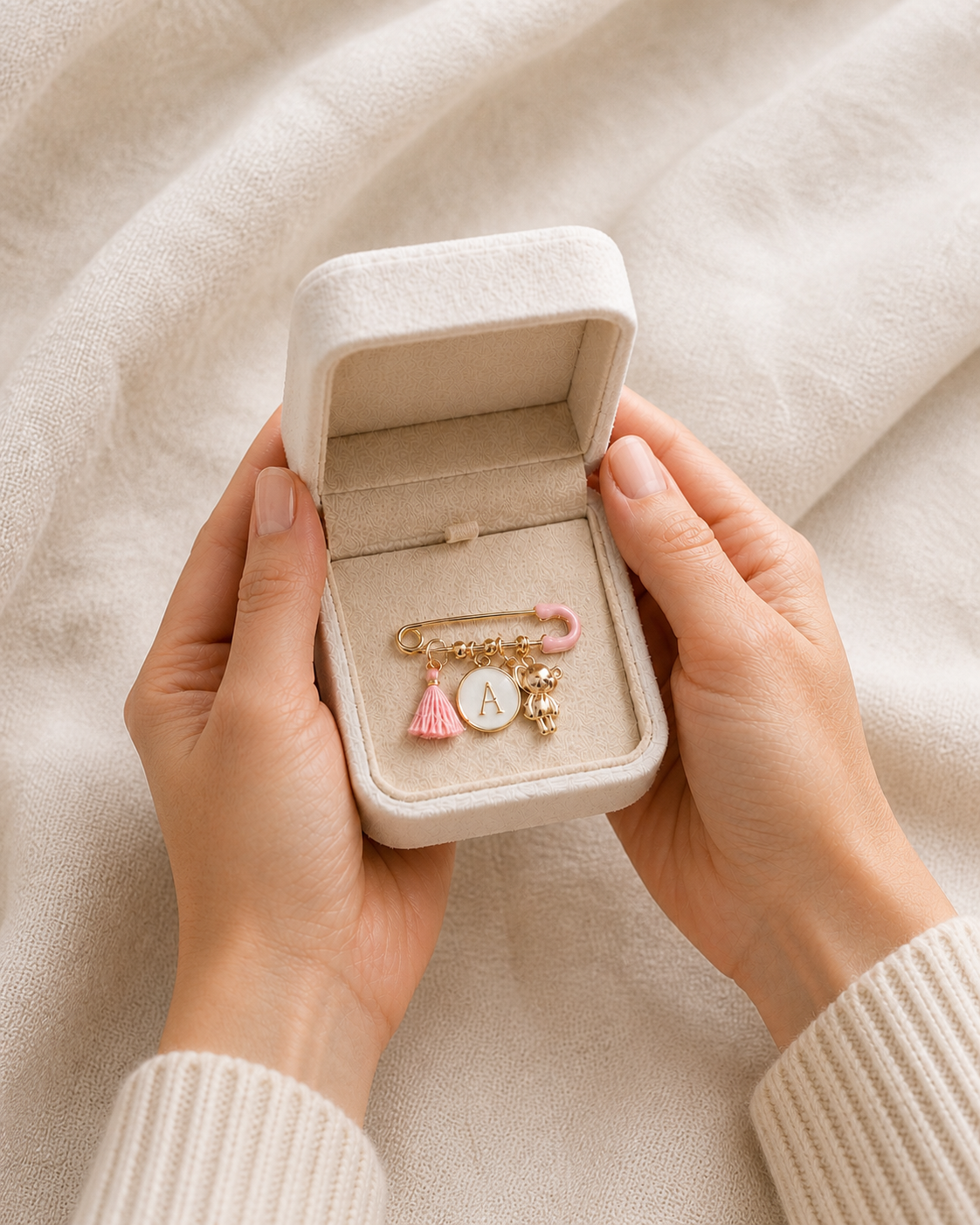 Jewelry box with charms held by hands on a beige fabric background